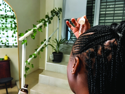 Founder of 12 Teaspoons applying natural haircare product, demonstrating how GS1 GTINs and trusted product identification support business growth and marketplace readiness.