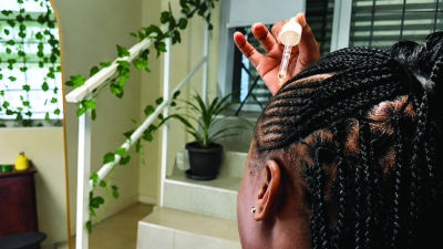 Founder of 12 Teaspoons applying natural haircare product, demonstrating how GS1 GTINs and trusted product identification support business growth and marketplace readiness.