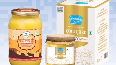 Three cow-ghee products—a 1L Badri Cow Ghee glass jar with Uttarakhand mountain-scene label, a Mother Dairy Premium Gir Cow Ghee jar topped with rustic burlap, and a Mother Dairy Premium Cow Ghee retail box featuring a GS1 Digital Link QR code—with a QR Code powered by GS1 to enable traceability and end-to-end visibility in India’s dairy supply chain.