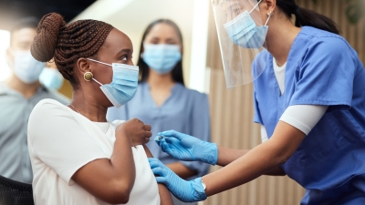 girl taking a vaccine and surrounded by nurses