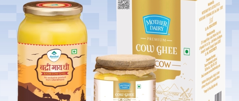 Three cow-ghee products—a 1L Badri Cow Ghee glass jar with Uttarakhand mountain-scene label, a Mother Dairy Premium Gir Cow Ghee jar topped with rustic burlap, and a Mother Dairy Premium Cow Ghee retail box featuring a GS1 Digital Link QR code—with a QR Code powered by GS1 to enable traceability and end-to-end visibility in India’s dairy supply chain.